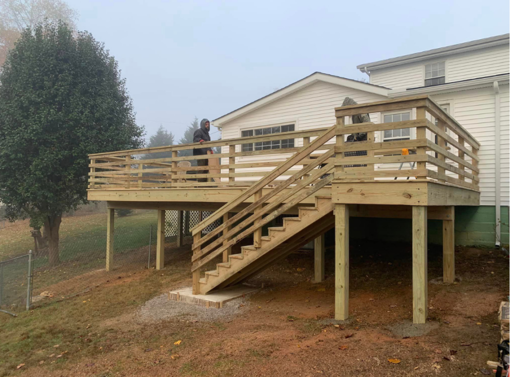 Wooden deck on back side of house with railing and stairs